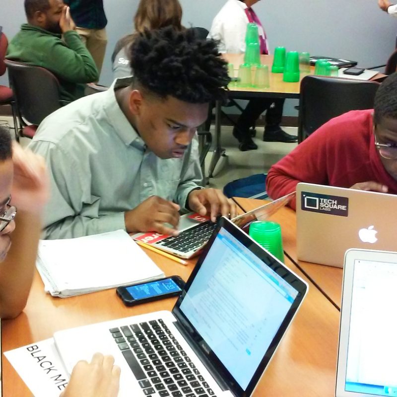 Morehouse College freshmen Philip Rucker, Damon Redding and Tyree Stevenson use a programming language called Python to plot a map of weather stations in the United States.